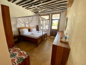 a bedroom with a bed and a table in a room at Zuzanu house in Nungwi