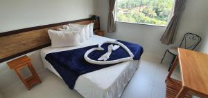 a hotel room with a bed with a horseshoe on it at Hotel Escarpas do Lago By San Diego in Capitólio