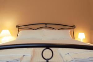 1 dormitorio con 1 cama con almohadas y 2 lámparas en BnButler - Isonzo - Luminoso Appartamento in Porta Romana en Milán