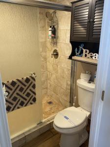 ein Bad mit einem WC und einer Dusche in der Unterkunft Ocean View Renovated Condo With Pool - DAYTONA BEACH in Daytona Beach