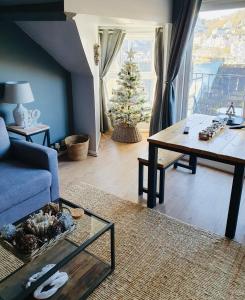 a living room with a christmas tree and a blue couch at Looe with a View - Entire apartment with FREE allocated parking in Looe