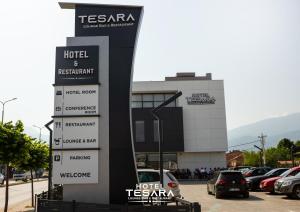 un edificio con coches estacionados en un estacionamiento en Hotel Tesara, en Prizren