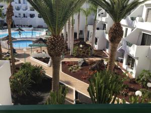 an image of a resort with palm trees and a pool at casa de los amigos in Tías