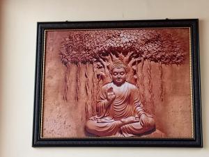 a painting of a buddha sitting under a tree at RRR RESORTS TIRTHAN Valley by RRR HOTELS & RESORTS in Banjār