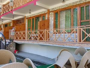 un balcón de una casa con mesa y sillas en RRR RESORTS TIRTHAN Valley by RRR HOTELS & RESORTS en Banjār