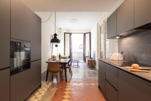 a kitchen with a table and a dining room at AB Centric Universitat in Barcelona