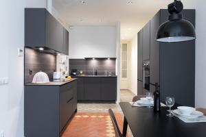 a kitchen with black cabinets and a dining table at AB Centric Universitat in Barcelona