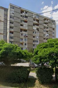 a large apartment building with cars parked in front of it at Henriett’s cosy places in Satu Mare