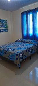 Bett in einem Zimmer mit blauen Vorhängen in der Unterkunft sweet Home alto Boquete 