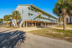 a large white building with palm trees in front of it at The Cove in Gulf Shores