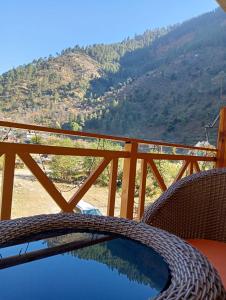 una mesa y sillas con vistas a la montaña en RRR RESORTS TIRTHAN Valley by RRR HOTELS & RESORTS en Banjār