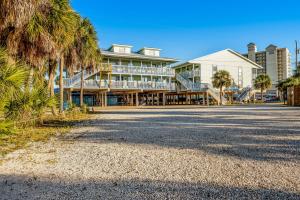 a large building on the beach with palm trees at The Cove in Gulf Shores