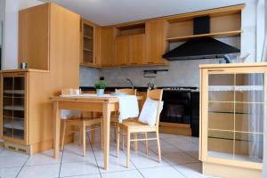 a kitchen with wooden cabinets and a table and chairs at Casa Mottes in Fai della Paganella
