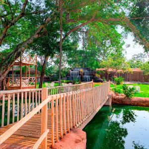 un puente de madera sobre un estanque en un jardín en Pousada Grande Rio en Pirapora