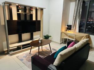 a living room with a couch and a tv at Damen Suite Sunway Subang by DW in Subang Jaya