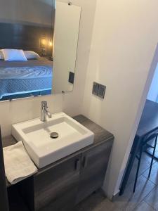 a bathroom with a sink and a mirror and a bed at Quinta del sol in Chihuahua