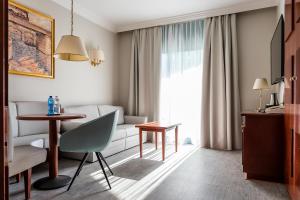 - un salon avec une table et un canapé dans l'établissement Mediterranee Family & Spa Hotel, à Bibione