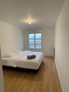 a bedroom with a bed and a large window at Appartement Saint ouen proche stade de france in Saint-Ouen