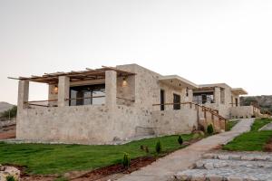 a stone house with a pathway leading up to it at Alagni Cretan Resort in Stíronas