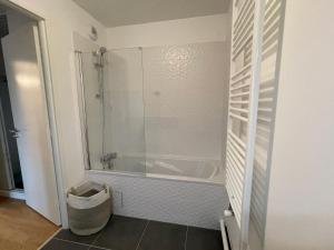 a bathroom with a tub and a glass shower at Appartement Saint ouen proche stade de france in Saint-Ouen