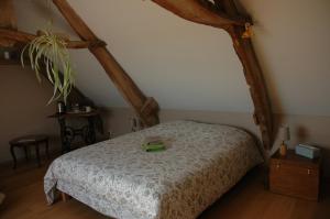 una camera da letto con un letto con un libro sopra di Chambre d'Hôte La Maison du Mesnil a Saint-Hilaire-Petitville