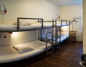 grupa łóżek piętrowych w pokoju w obiekcie Akureyri Backpackers w Akureyri