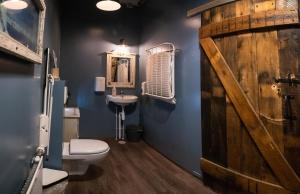 een badkamer met een toilet, een wastafel en een houten deur bij Akureyri Backpackers in Akureyri