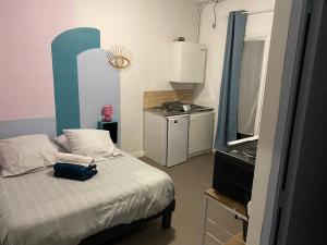 a small bedroom with a bed with a bag on it at Résidence La Cigale du Désire Séjour chez l habitant in Riez