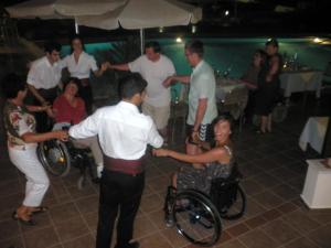 um grupo de pessoas em cadeiras de rodas dançando em uma festa em ERIA RESORT for people with special abilities em Maleme