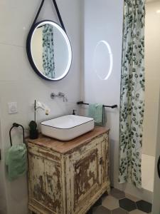 uma casa de banho com um lavatório e um espelho em Joséphine em Bastia