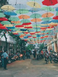 NGỌC HƯNG HOTEL في فينه لونج: مجموعة من المظلات المعلقة على شارع