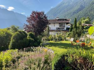 a garden with a house and mountains in the background at Komfortable Ferienwohnung mit herrlicher Aussicht in Sautens