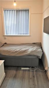 Bett in einem Zimmer mit Fenster in der Unterkunft Single Bedroom In Withington M20 1 Single Bed, RM4 in Manchester