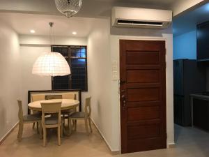a dining room with a table and chairs and a door at The Rockview Bayu Emas Penang Near Beach in Batu Ferringhi