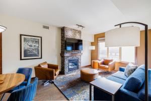 a living room with a blue couch and a fireplace at Stoneridge Mountain Resort in Canmore