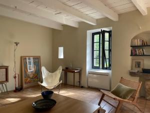 a living room with a table and chairs and a window at La Maison Du Village in Val-de-Dagne