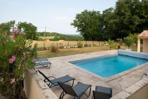 a swimming pool in a yard with chairs at gites de la Vaysse in Vergt-de-Biron