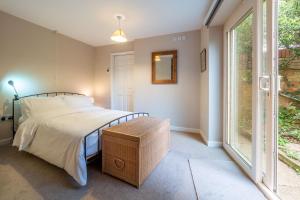 a bedroom with a bed and a large window at The Pines in Aldeburgh