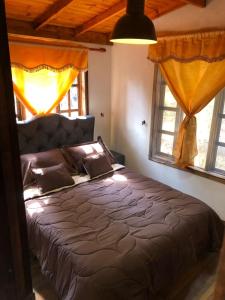 a bedroom with a bed in a room with windows at La Arboleda in Tilatá