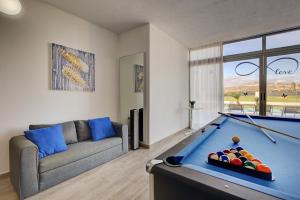 ein Wohnzimmer mit einem Billardtisch und einem Sofa in der Unterkunft Luxury Villa Cindy in Caleta de Fuste