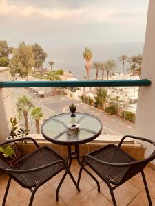 einen Tisch und Stühle auf einem Balkon mit Meerblick in der Unterkunft טבריה in Tiberias