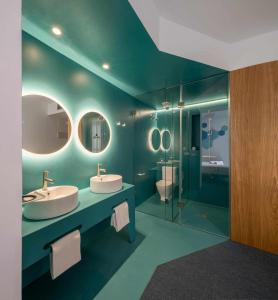 uma casa de banho com 2 lavatórios e uma cabina de duche em vidro. em Nature by Raidom em Alicante