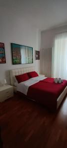 1 dormitorio con 1 cama grande con manta roja en Casa Flora, en Taranto