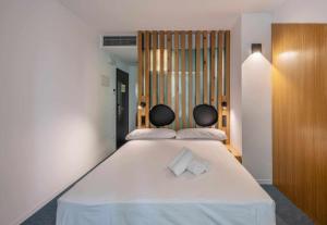 a bedroom with a large white bed with two chairs at Nature by Raidom in Alicante