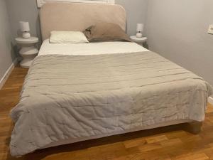 a large bed in a bedroom with two night stands at Catedral Plaza in Murcia