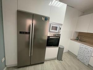 a kitchen with a stainless steel refrigerator and a microwave at Catedral Plaza in Murcia