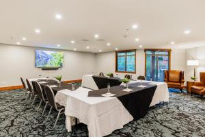 uma sala de conferências com mesas e cadeiras e uma televisão de ecrã plano em Stoneridge Mountain Resort em Canmore