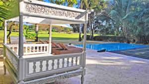 a porch with an umbrella next to a pool at CASA BALI Juan Dolio Beach in Juan Dolio