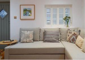 a couch with pillows in a living room at The Snug Entire home Sleeps 2, Stratford upon Avon in Shottery