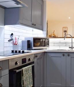 a kitchen with a stove and a microwave at The Snug Entire home Sleeps 2, Stratford upon Avon in Shottery +8 photos